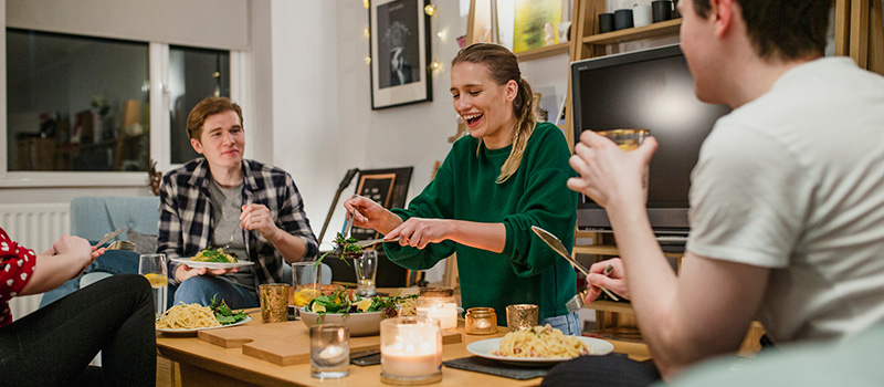 Young people sitting around a table eating