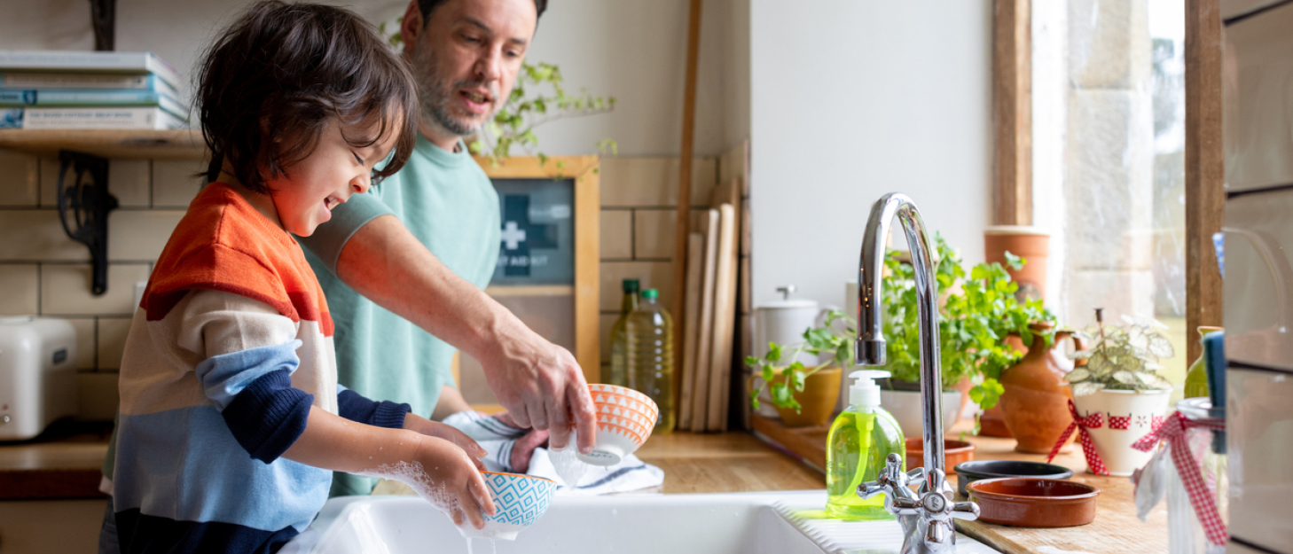 Man and child at the kitchen sink